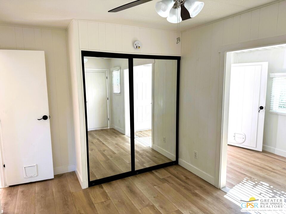 17850 Corkill Road, Unit 94 Desert Hot Springs, CA 92241 - Photo 19 of 39 a view of a hallway with wooden floor and a ceiling fan