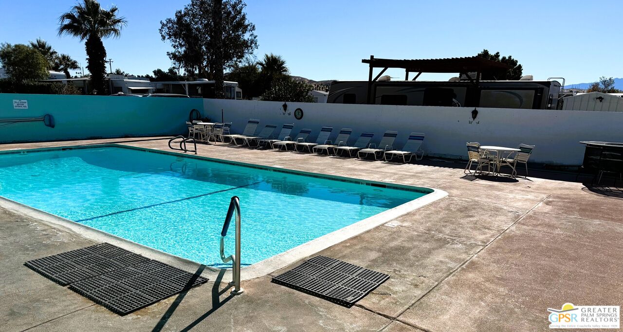 17850 Corkill Road, Unit 94 Desert Hot Springs, CA 92241 - Photo 34 of 39 a view of a swimming pool with a yard