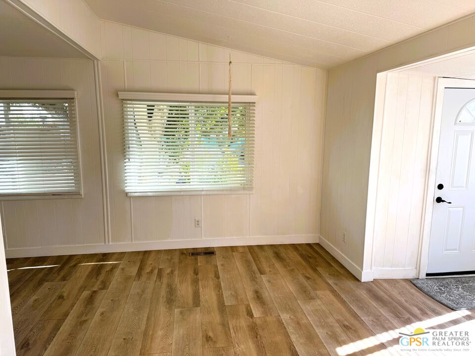 17850 Corkill Road, Unit 94 Desert Hot Springs, CA 92241 - Photo 10 of 39 a view of an empty room with wooden floor and a window