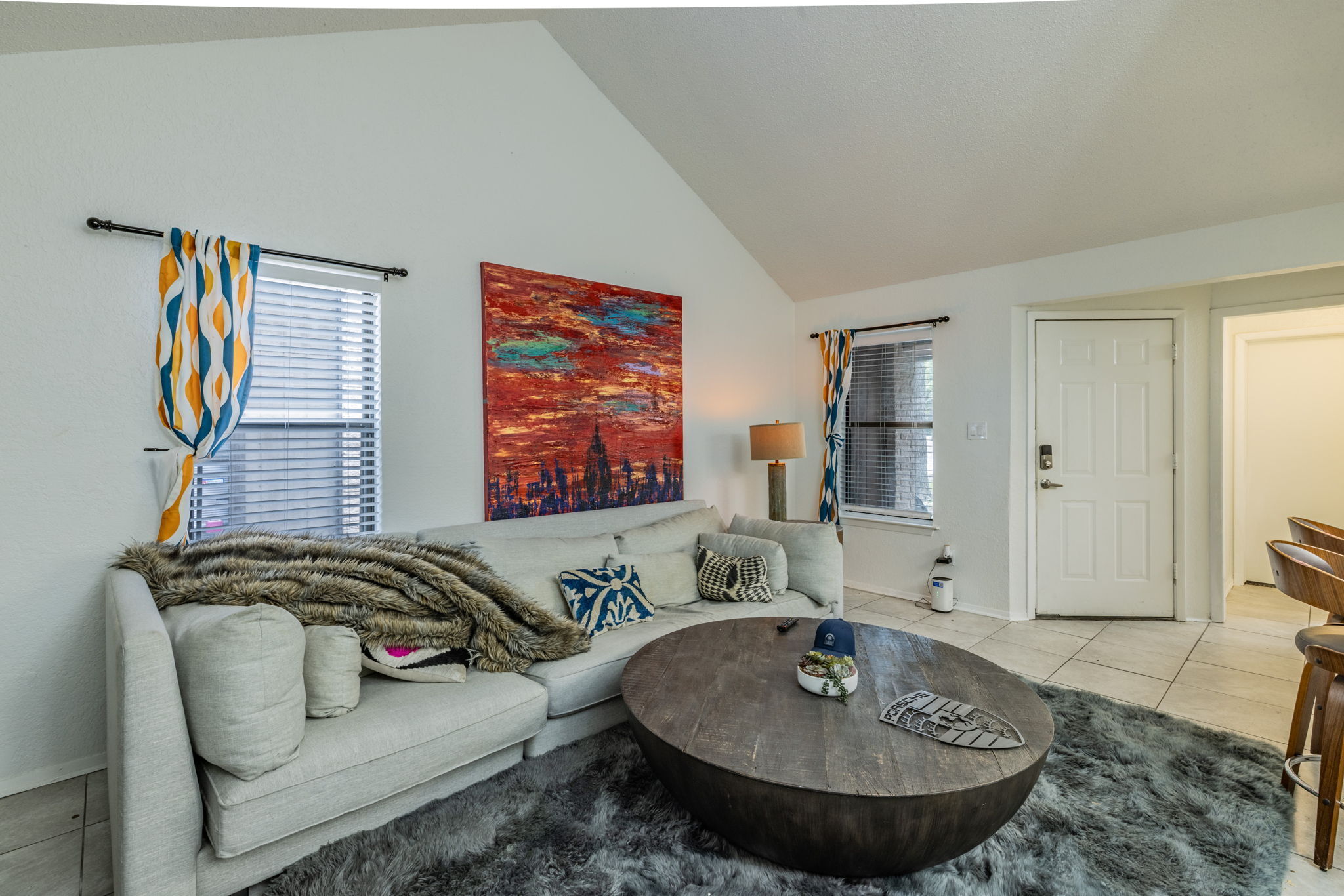 1008 Milford Way Austin, TX 78745 - Photo 23 of 40 Living area featuring a vaulted ceiling and two windows with blinds