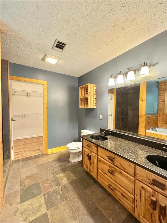 280 Owens Road Fort Mitchell, AL 36856 - Photo 17 of 56 Full bathroom with toilet, double vanity, a walk in closet, a tub to relax in, and baseboards