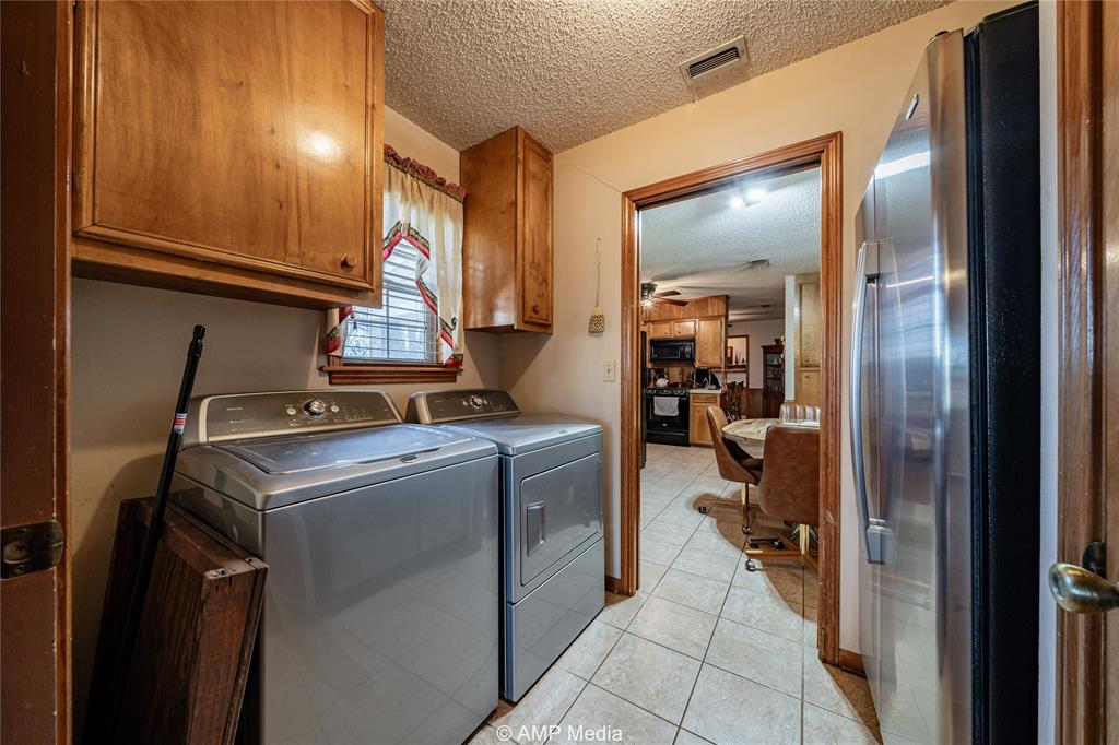 1992 Sand Flat Road Jacksboro, TX 76458 - Photo 26 of 36 Clothes washing area featuring cabinets, a textured ceiling, light tile patterned floors, ceiling fan, and washing machine and dryer