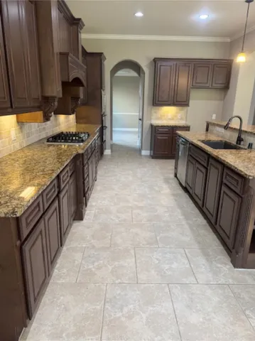a kitchen with kitchen island granite countertop a sink cabinets and window