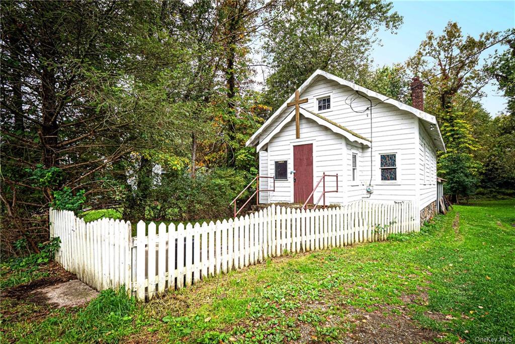 a view of a house with a small yard and wooden fence