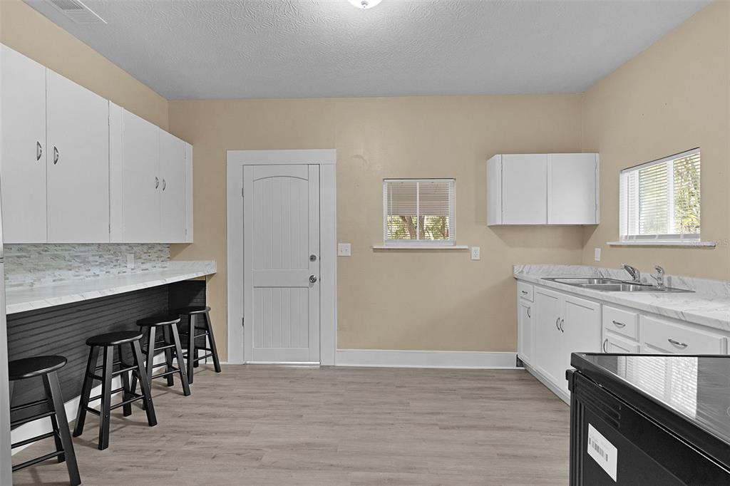 2245 Northwest 63rd Place Ocala, FL 34475 - Photo 14 of 38 a kitchen with granite countertop a stove a sink and a refrigerator