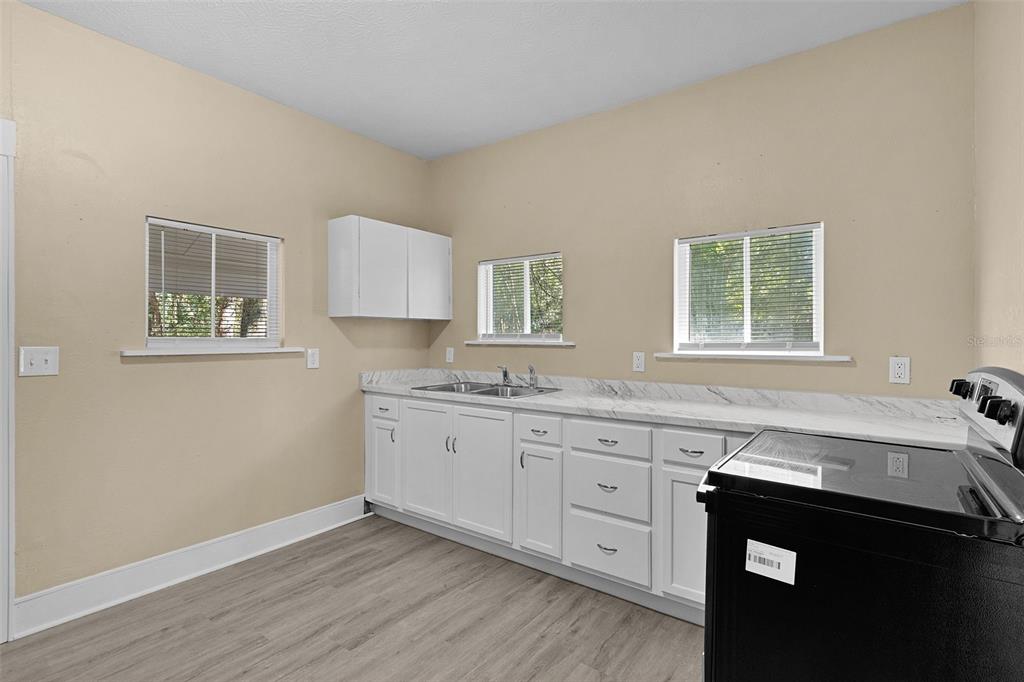 2245 Northwest 63rd Place Ocala, FL 34475 - Photo 16 of 38 a kitchen with granite countertop a sink and a wooden floor
