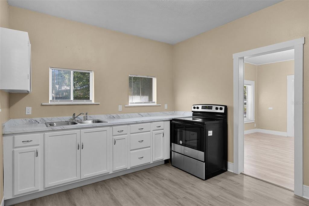 2245 Northwest 63rd Place Ocala, FL 34475 - Photo 18 of 38 a kitchen with granite countertop white cabinets and stainless steel appliances