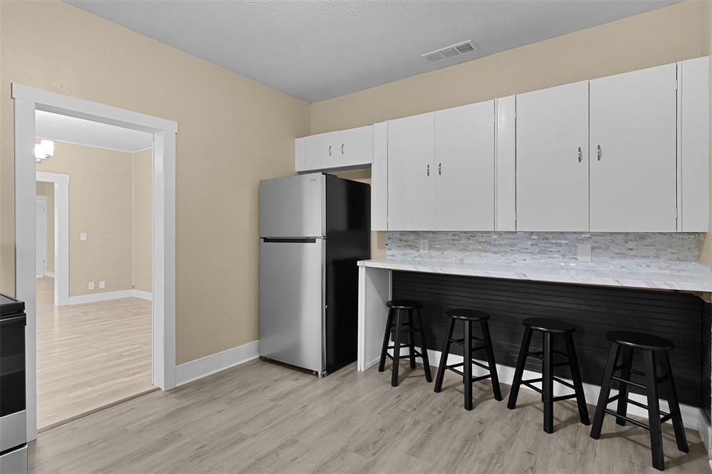 2245 Northwest 63rd Place Ocala, FL 34475 - Photo 19 of 38 a kitchen with granite countertop a refrigerator and a stove top oven