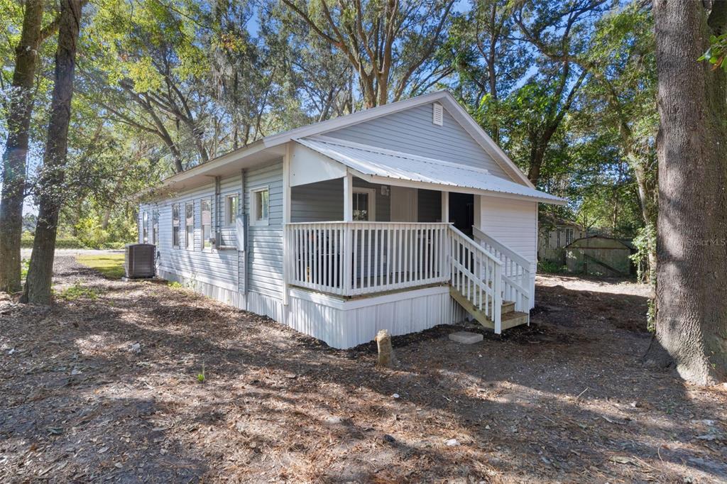 2245 Northwest 63rd Place Ocala, FL 34475 - Photo 37 of 38 a view of a small house with a yard and large trees