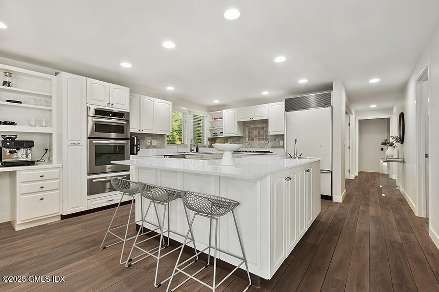 254 Stanwich Road Greenwich, CT 06830 - Photo 12 of 52 a kitchen with kitchen island wooden floors appliances and white cabinets
