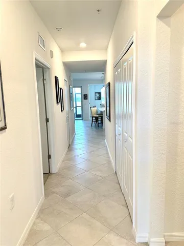 a view of a hallway with wooden floor and a living room