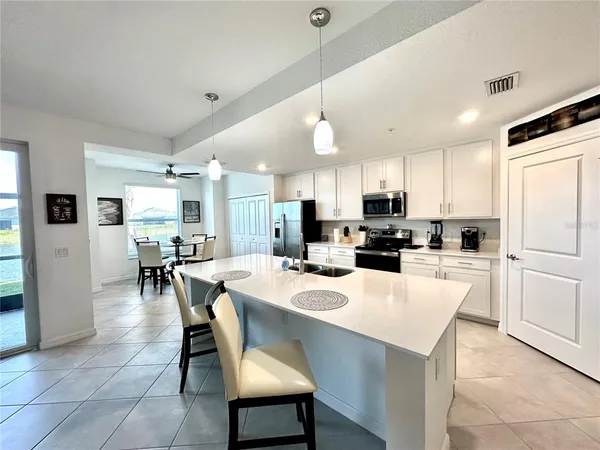 a kitchen with a dining table chairs refrigerator and microwave