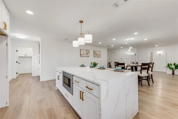 a large kitchen with kitchen island a large island in it