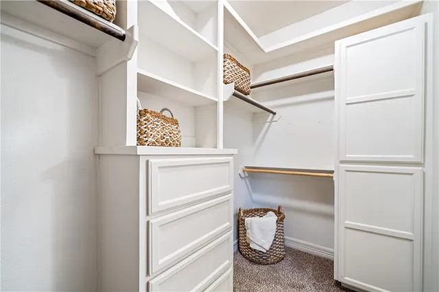 a view of walk in closet with clothes and shoes
