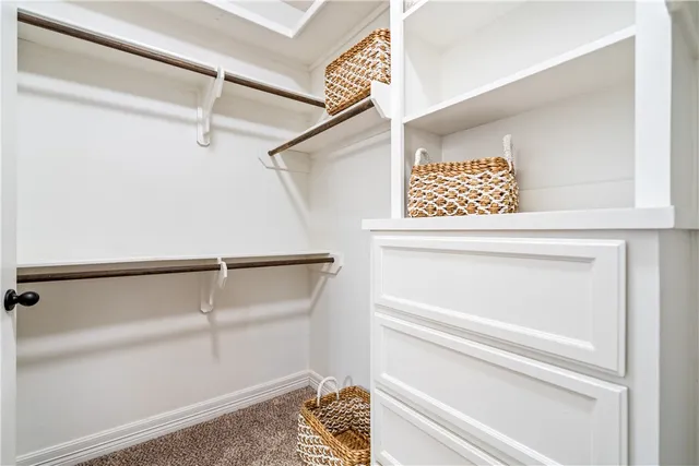 a view of walk in closet with clothes