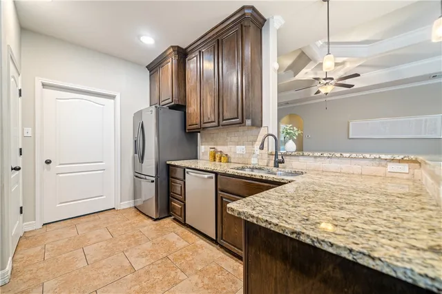 a kitchen with stainless steel appliances granite countertop a sink refrigerator and microwave