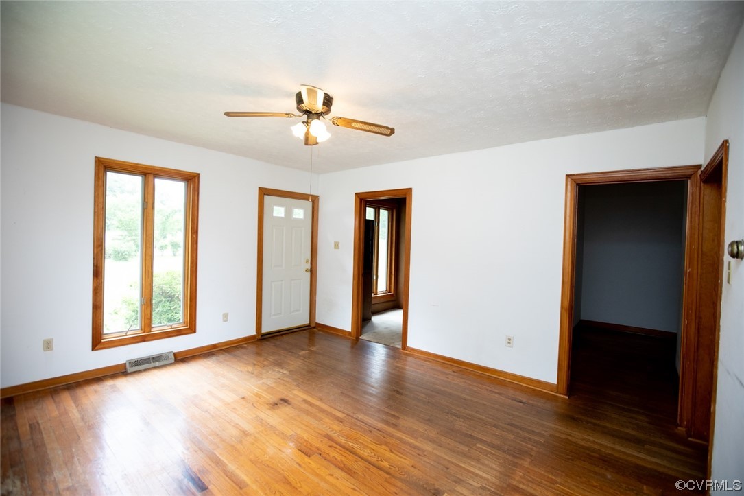 71 Spillman Road Farmville, VA 23901 - Photo 4 of 48 an empty room with wooden floor chandelier fan and windows