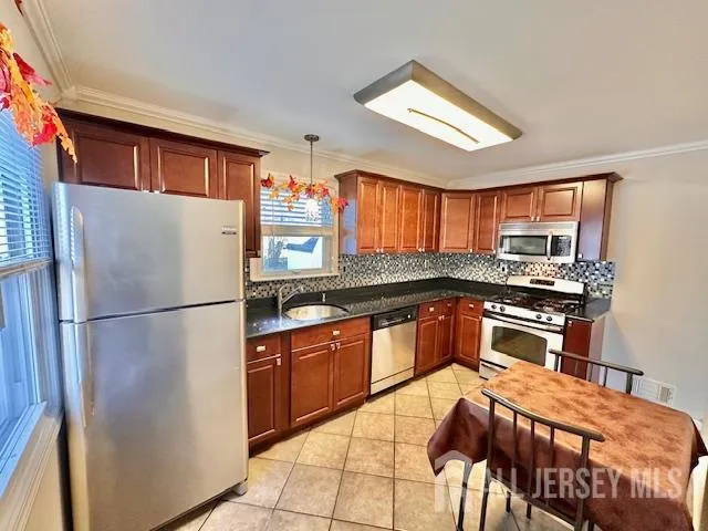 a kitchen with stainless steel appliances granite countertop a refrigerator sink and wooden cabinets