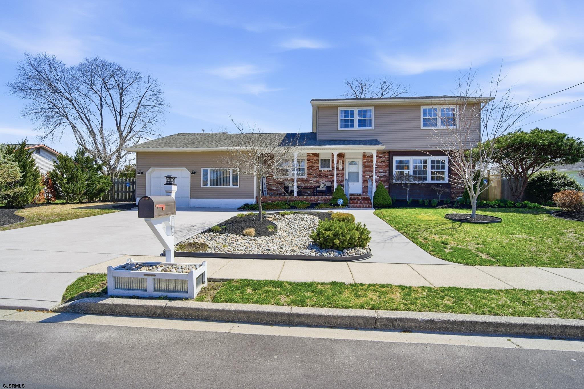 a front view of a house with a garden and plants