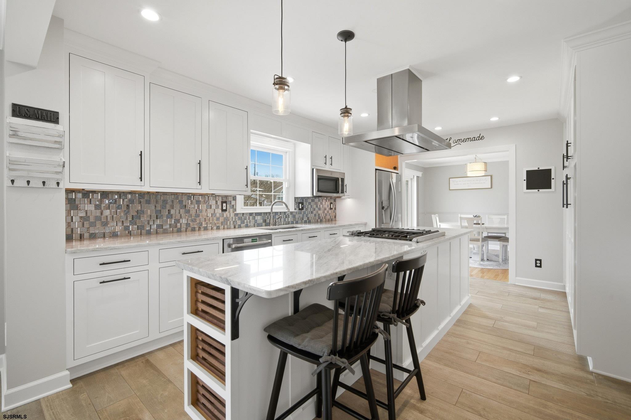 2104 Grove Road Northfield, NJ 08225 - Photo 10 of 33 a kitchen with stainless steel appliances kitchen island a wooden floor and white cabinets