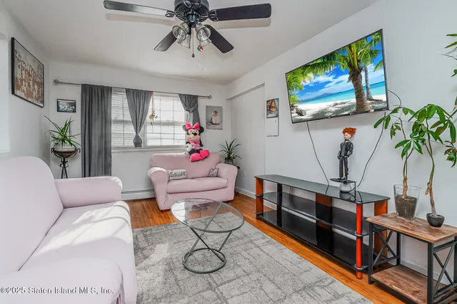 a living room with furniture potted plant and a flat screen tv