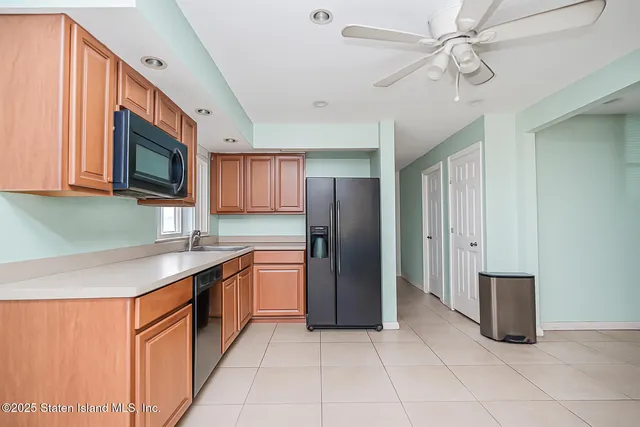 a kitchen with stainless steel appliances granite countertop a refrigerator a sink dishwasher a stove top oven a washer and dryer