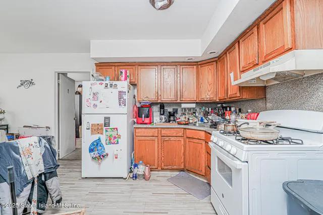 a view of a kitchen with fridge and workspace