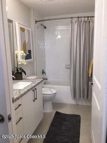 2750 Bosque Circle, Unit 304 Melbourne, FL 32940 - Photo 12 of 18 a bathroom with a granite countertop sink a toilet a mirror and shower