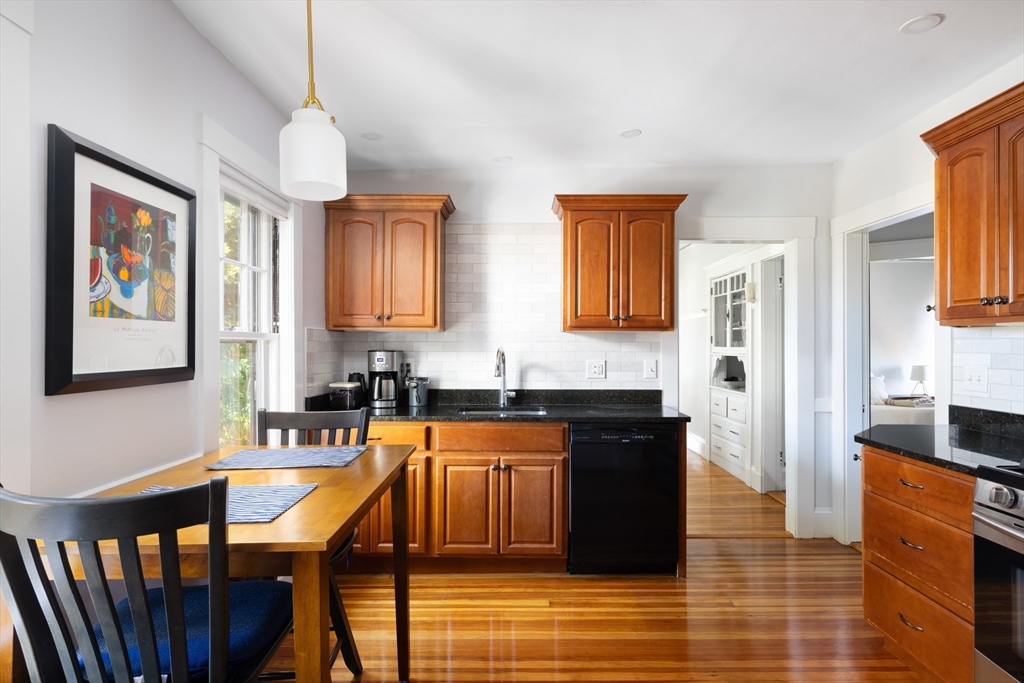 71 Congreve Street, Unit 2 Boston, MA 02131 - Photo 2 of 12 a large kitchen with granite countertop a stove a sink a refrigerator and wooden cabinets