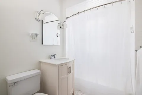 a bathroom with a sink a toilet and a mirror