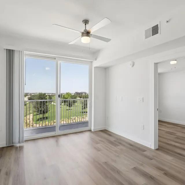 3130 Heritage Trail, Unit 1213 Denton, TX 76201 - Photo 19 of 39 an empty room with wooden floor fan and windows