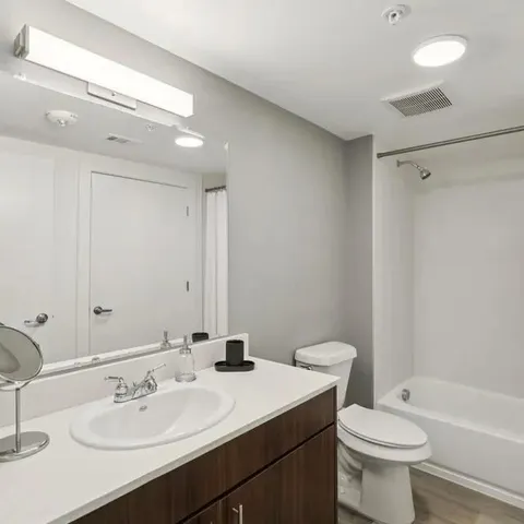 a bathroom with a sink a toilet and shower