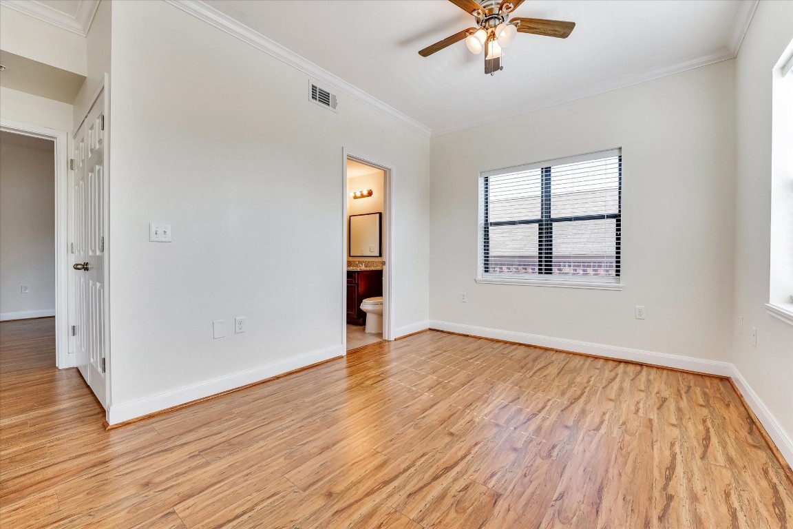 10102 Neuens Road, Unit A103 Houston, TX 77080 - Photo 12 of 23 an empty room with wooden floor chandelier fan and windows