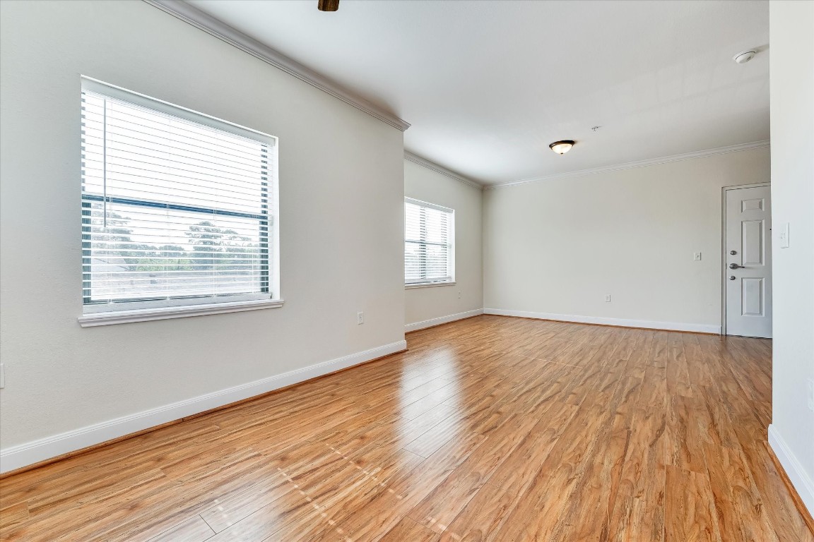 10102 Neuens Road, Unit A103 Houston, TX 77080 - Photo 13 of 23 a view of an empty room with wooden floor and a window