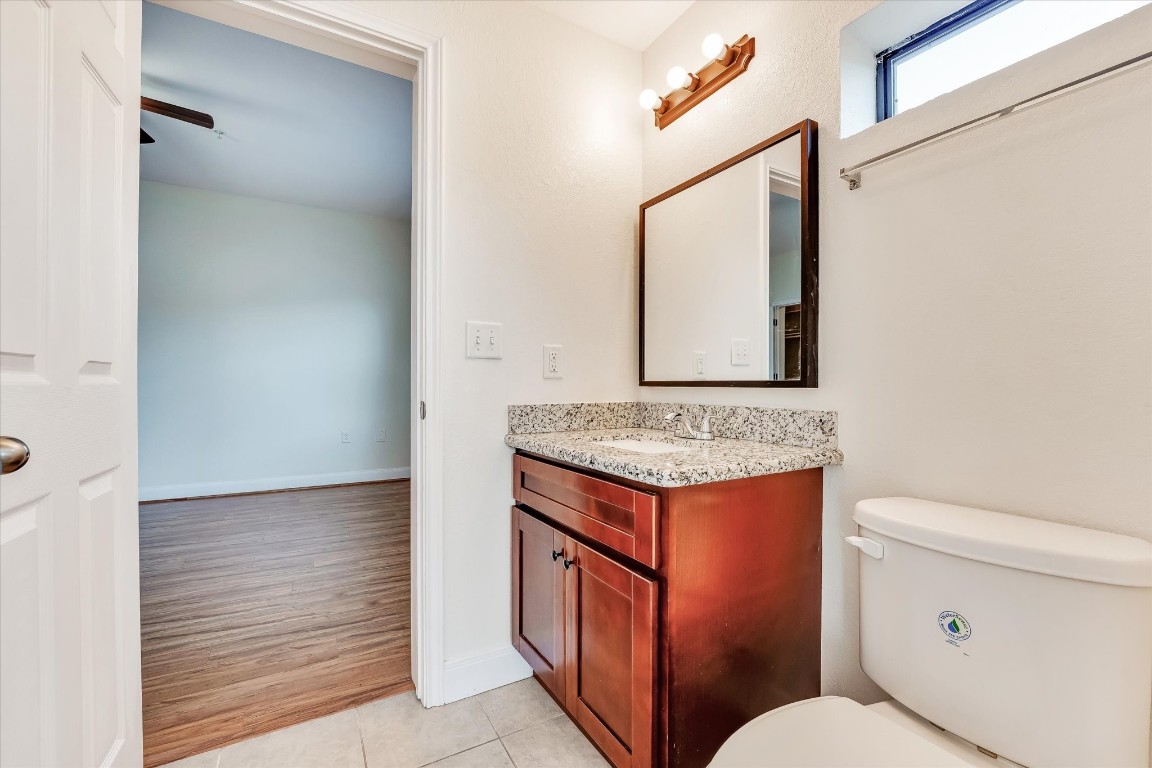 10102 Neuens Road, Unit A103 Houston, TX 77080 - Photo 17 of 23 a bathroom with a granite countertop toilet sink and mirror