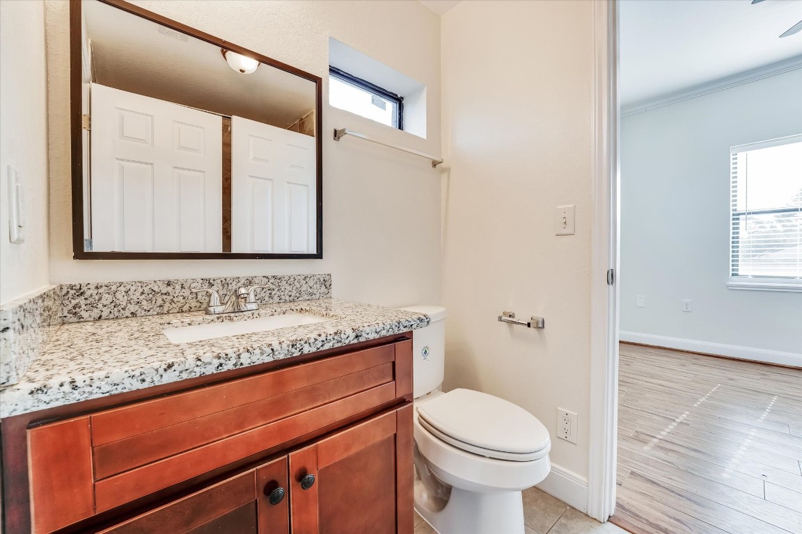 10102 Neuens Road, Unit A103 Houston, TX 77080 - Photo 18 of 23 a bathroom with a granite countertop sink toilet and mirror