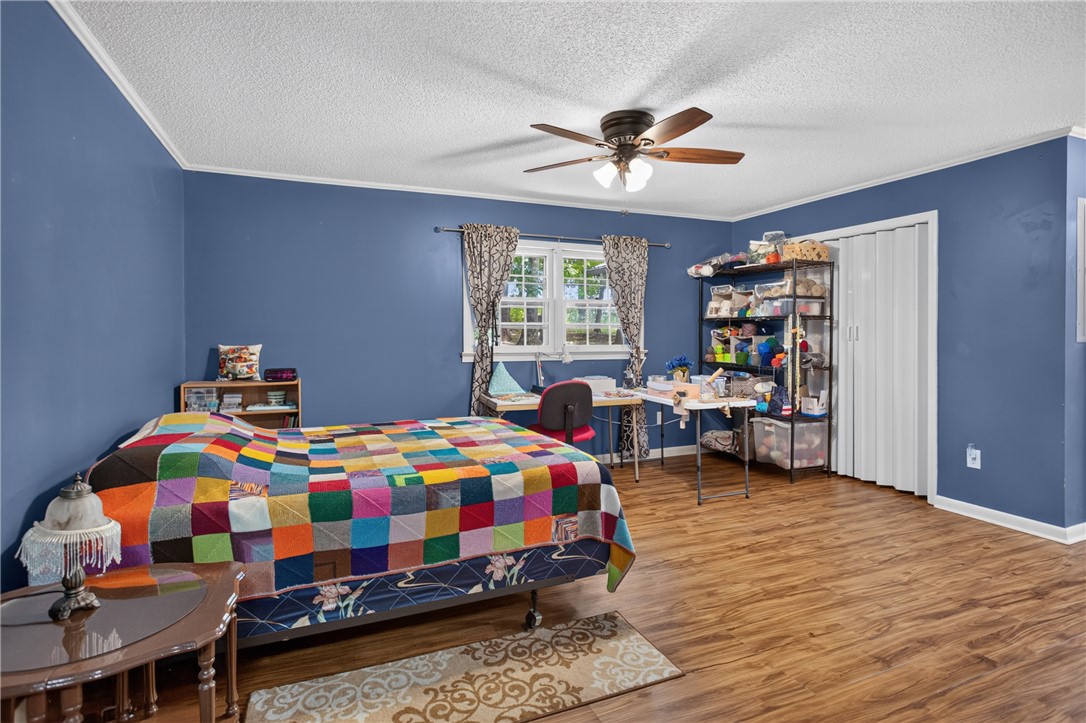 230 Dickard Road Seneca, SC 29672 - Photo 12 of 25 A comfortable bedroom with rich blue walls and warm wood-look flooring invites relaxation.