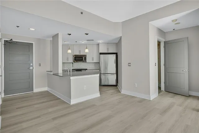 a view of kitchen with wooden floor and electronic appliances