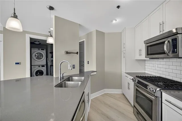 a kitchen with stainless steel appliances granite countertop a stove a sink and a microwave