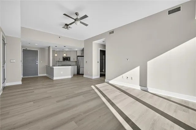 a view of a living room with a ceiling fan hardwood floor and a ceiling fan
