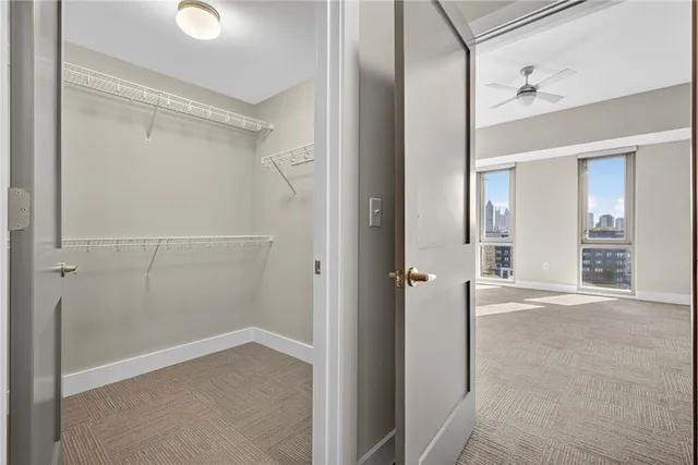 an empty room with fan and windows