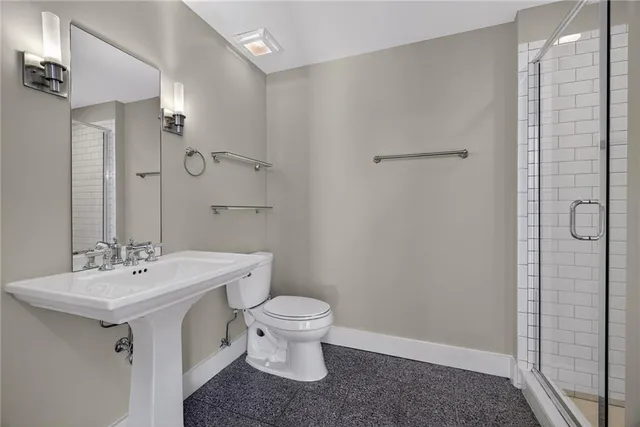 a bathroom with a granite countertop toilet and a shower
