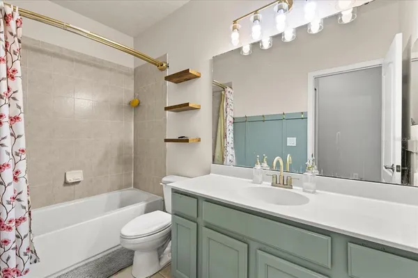 a bathroom with a sink a toilet a mirror a bathtub and shower