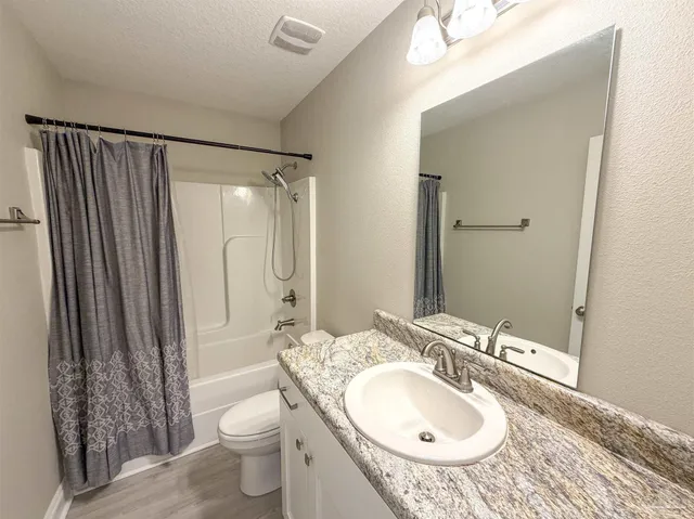 a bathroom with a sink a toilet and shower curtain