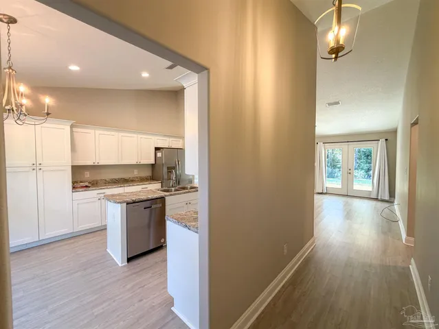 a kitchen with kitchen island granite countertop a sink cabinets and stainless steel appliances