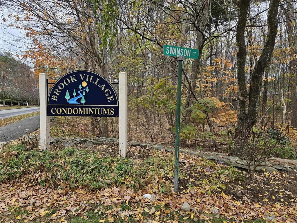 a sign board with tree in the background