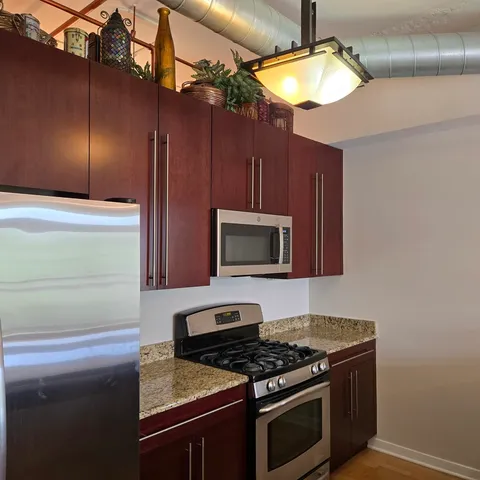 a kitchen with stainless steel appliances granite countertop a stove and a microwave