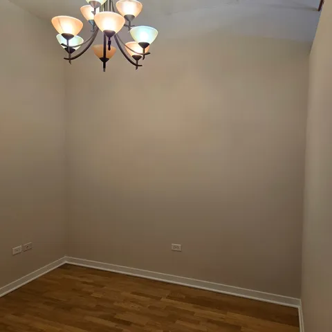 a view of a small space with wooden floor and a chandelier
