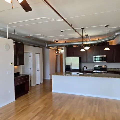 a kitchen with stainless steel appliances granite countertop a sink and a refrigerator