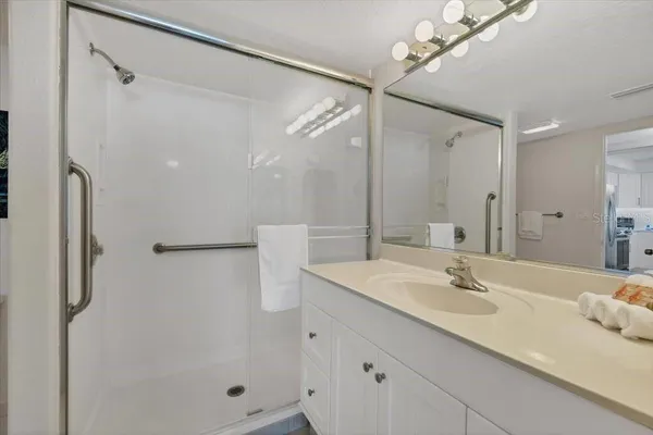 a bathroom with a double vanity sink mirror and shower